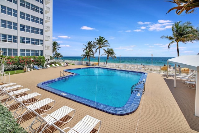 view of swimming pool with a patio area and a water view