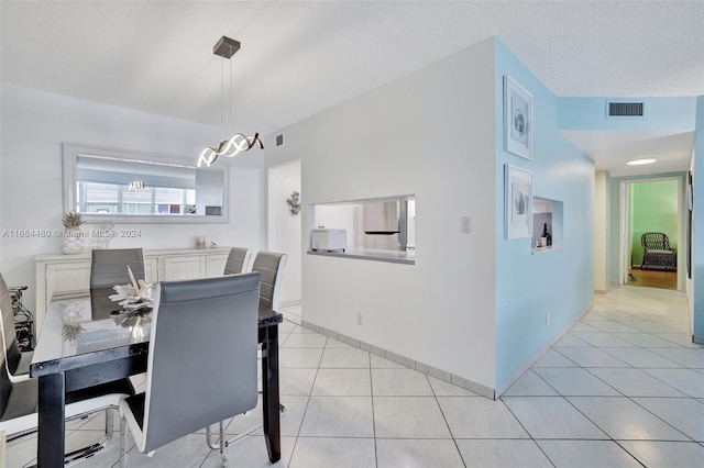 tiled dining room with a textured ceiling