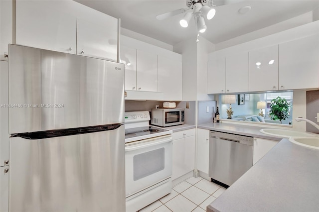 kitchen featuring appliances with stainless steel finishes, light tile patterned floors, sink, white cabinets, and ceiling fan