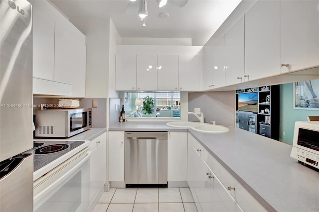 kitchen with stainless steel appliances, white cabinetry, sink, and light tile patterned floors