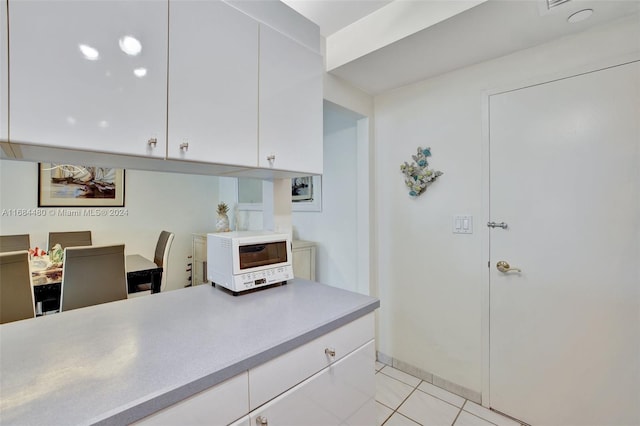 kitchen featuring white cabinets and light tile patterned flooring