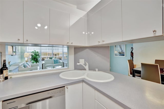 kitchen featuring dishwasher, a wealth of natural light, and white cabinets