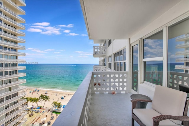 balcony featuring a water view and a beach view