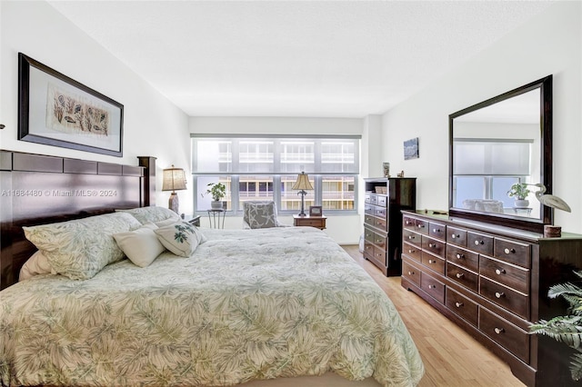 bedroom with light hardwood / wood-style floors and multiple windows