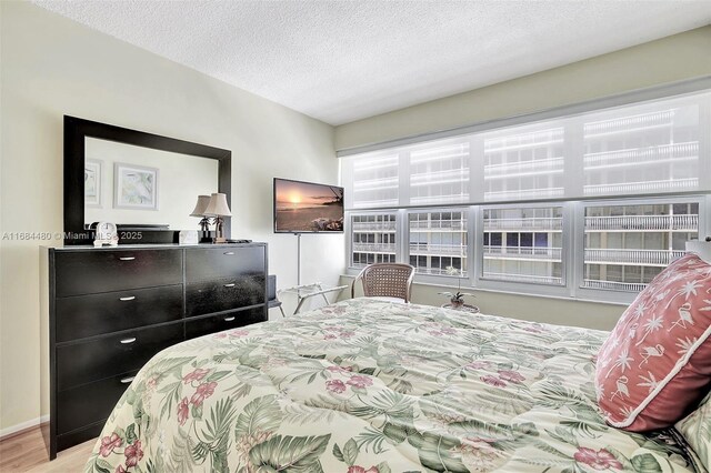 bedroom featuring light wood-type flooring and a textured ceiling