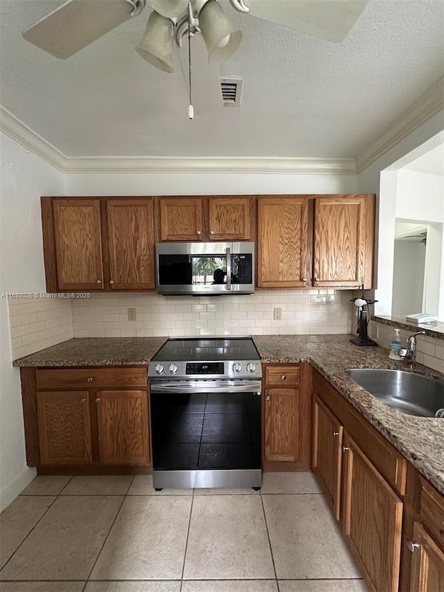 kitchen featuring ceiling fan, decorative backsplash, sink, and stainless steel appliances