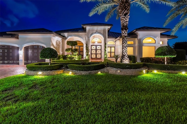 mediterranean / spanish-style house with a lawn and french doors