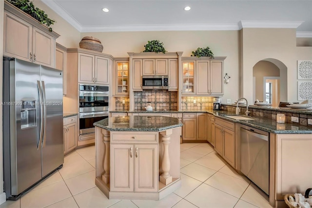 kitchen featuring light brown cabinets, sink, dark stone countertops, ornamental molding, and stainless steel appliances