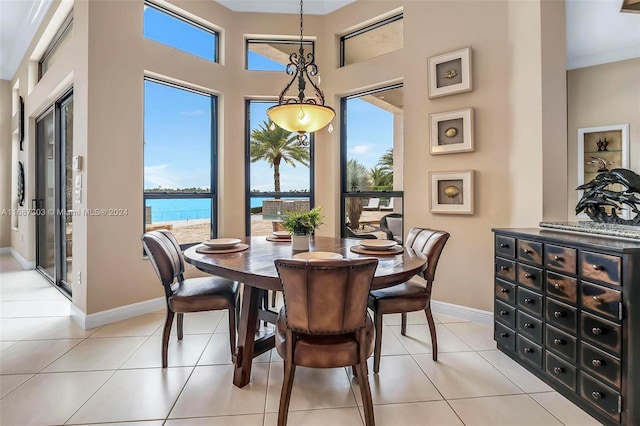 dining room featuring light tile patterned floors and a water view