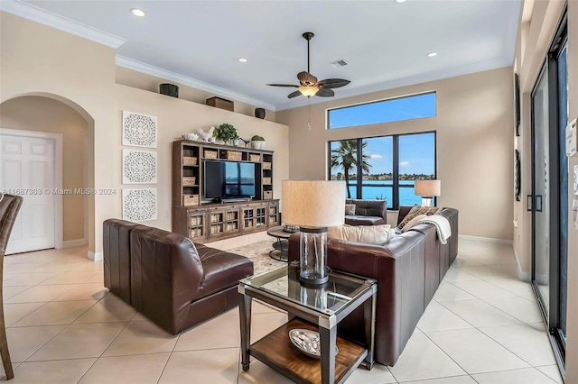 tiled living room with ceiling fan and ornamental molding