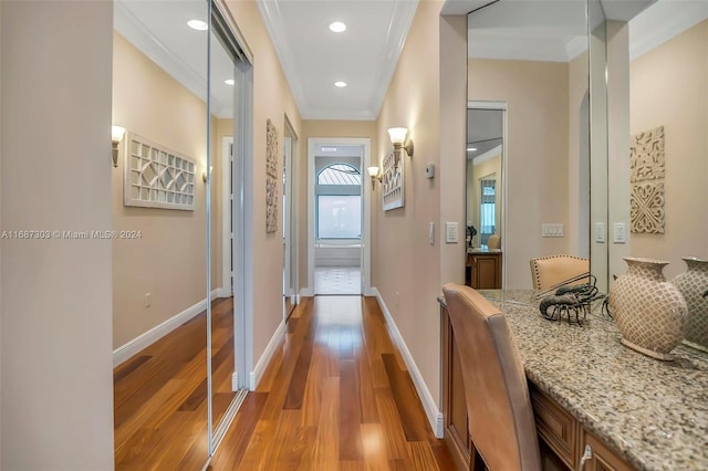 hall with hardwood / wood-style floors and ornamental molding