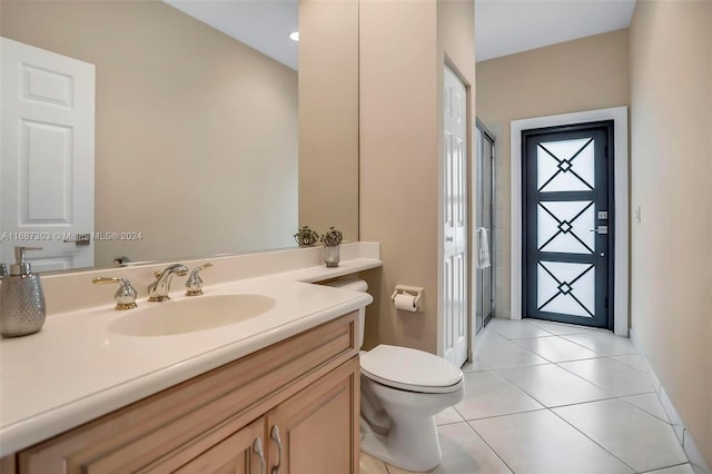 bathroom with tile patterned flooring, vanity, and toilet