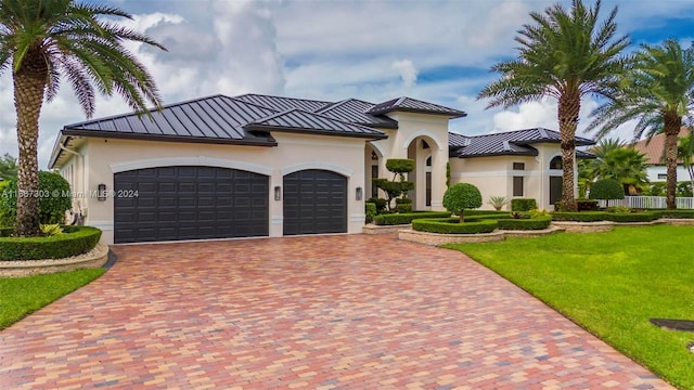 mediterranean / spanish-style home with a front lawn and a garage