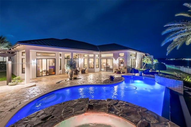 pool at twilight with a patio area