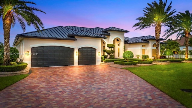 mediterranean / spanish-style home featuring a yard and a garage