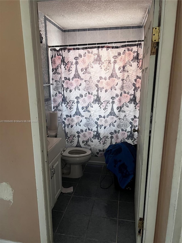 bathroom featuring tile patterned flooring, a textured ceiling, and toilet