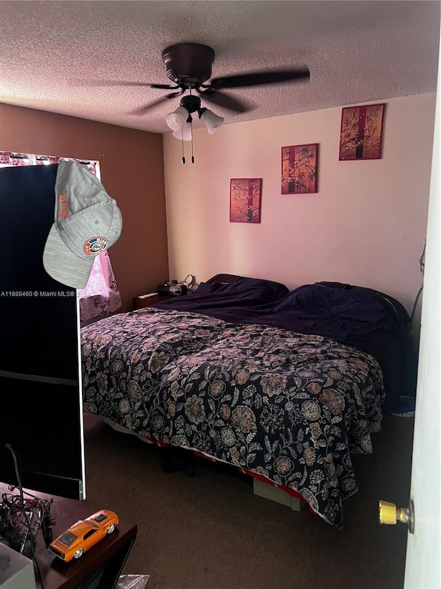 carpeted bedroom featuring a textured ceiling and ceiling fan