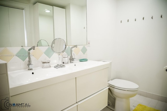 bathroom featuring tile patterned flooring, vanity, toilet, and backsplash