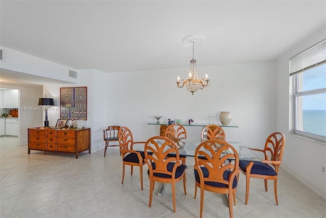 dining area with an inviting chandelier and a water view