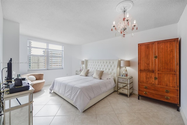 tiled bedroom with a notable chandelier and a textured ceiling