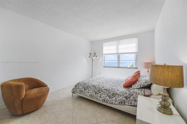 bedroom with a textured ceiling and light tile patterned floors