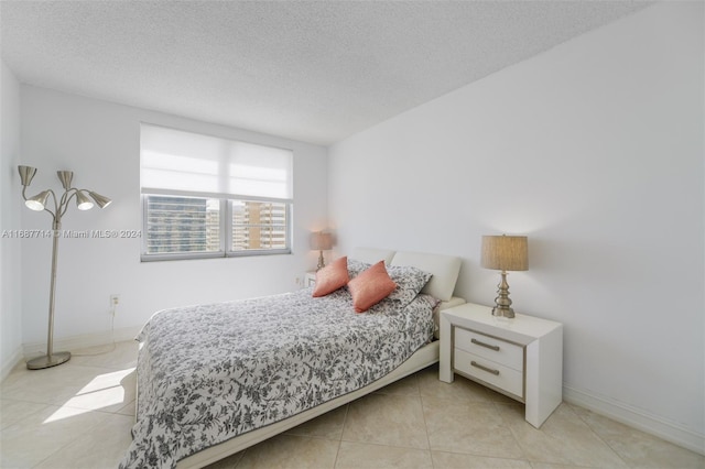 bedroom with a textured ceiling and light tile patterned floors