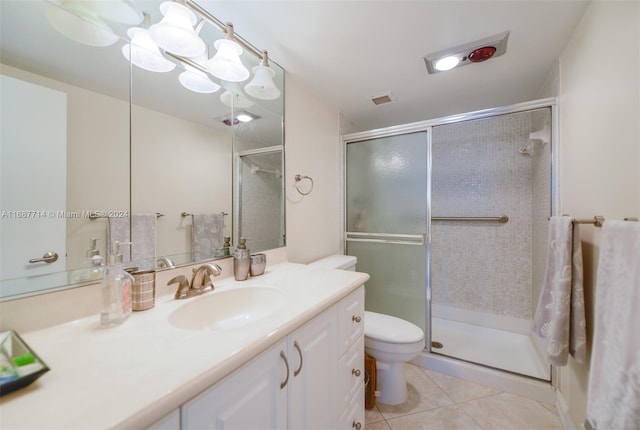 bathroom featuring tile patterned floors, vanity, toilet, and a shower with door