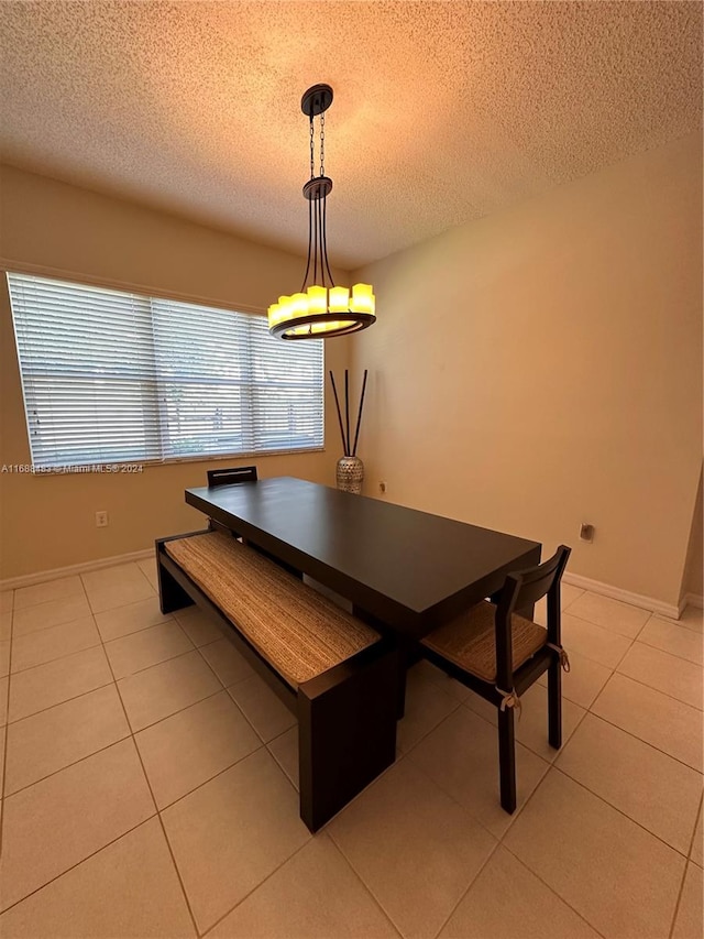 dining room with a textured ceiling and light tile patterned flooring