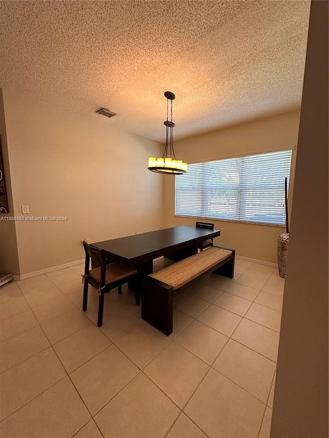 dining room with a textured ceiling and light tile patterned floors