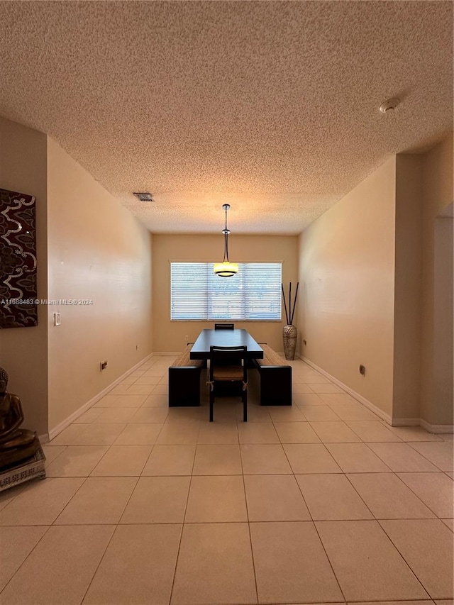 dining space with light tile patterned flooring and a textured ceiling