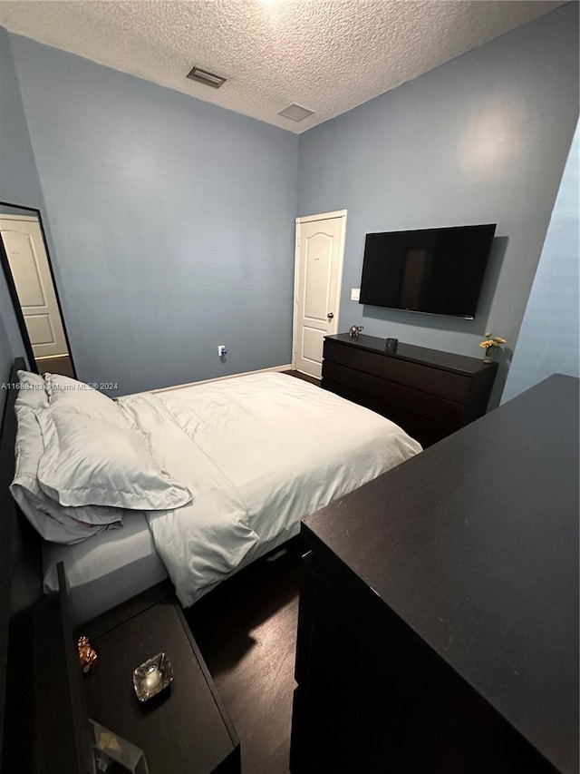 bedroom featuring hardwood / wood-style flooring and a textured ceiling