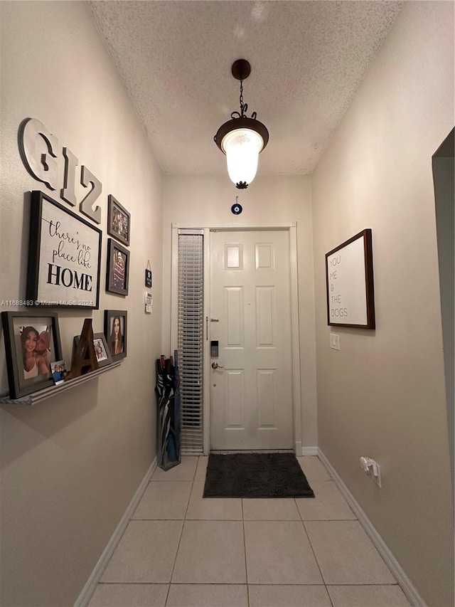 entryway with a textured ceiling and light tile patterned floors