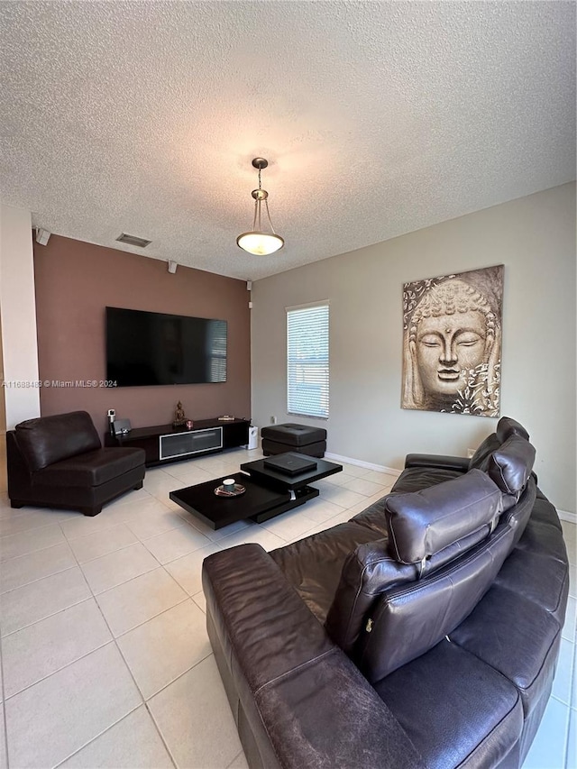 living room with a textured ceiling and light tile patterned floors