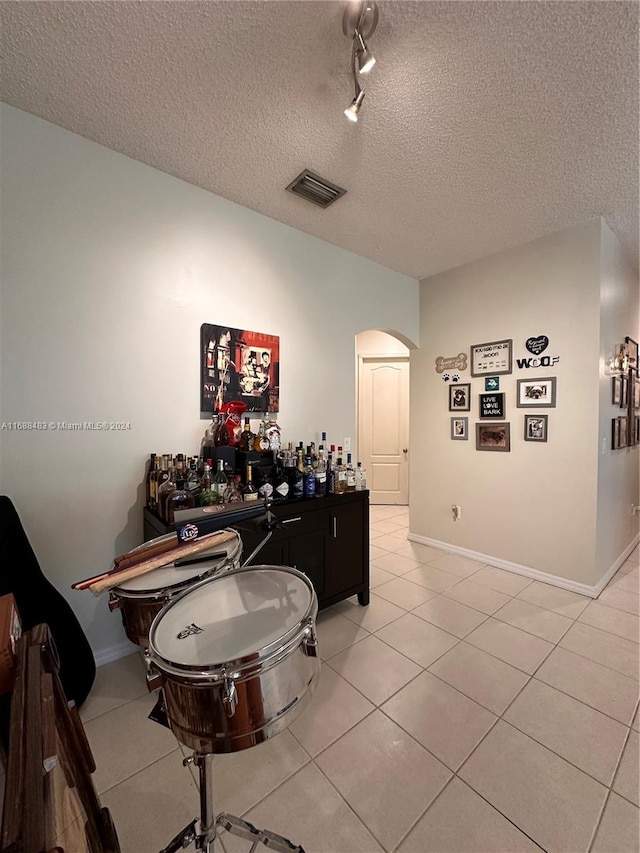 dining room featuring a textured ceiling and light tile patterned floors