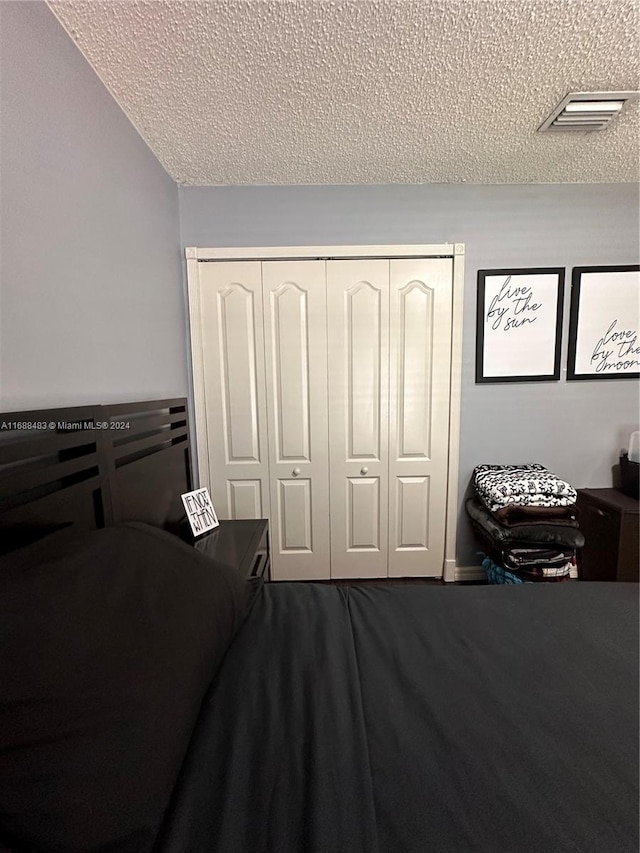 bedroom featuring a textured ceiling and a closet