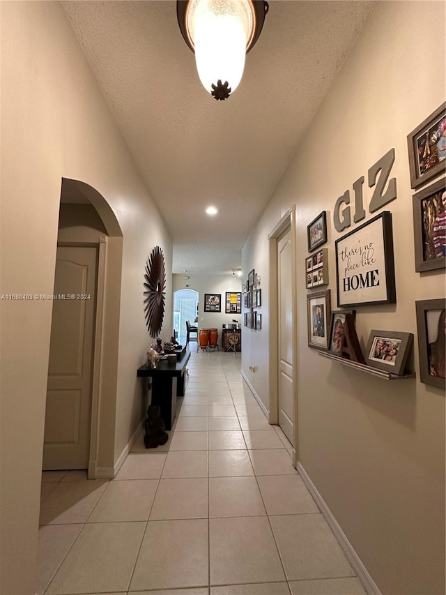 hallway with light tile patterned flooring and a textured ceiling