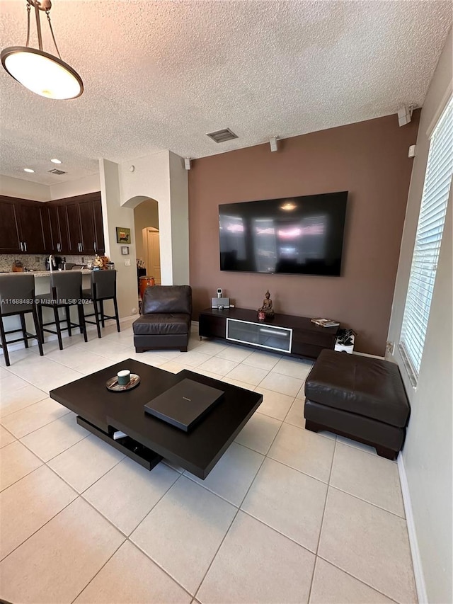 tiled living room with a textured ceiling