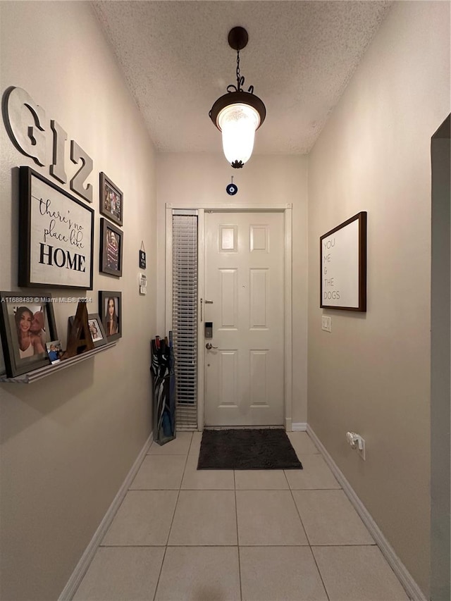 foyer featuring light tile patterned flooring and a textured ceiling