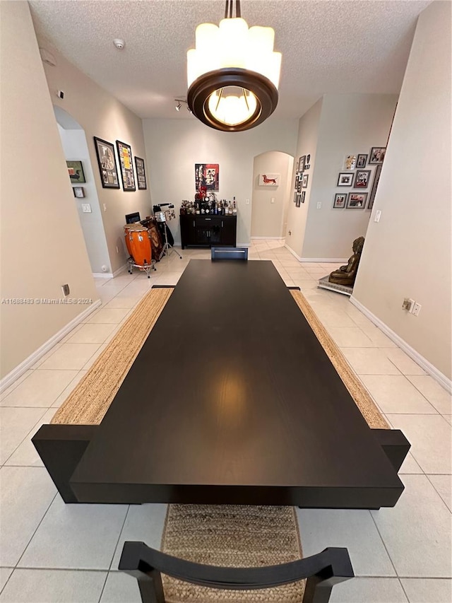 recreation room featuring a textured ceiling, light tile patterned floors, and an inviting chandelier