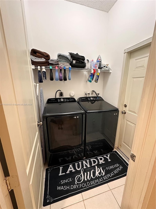 washroom with separate washer and dryer, a textured ceiling, and tile patterned floors