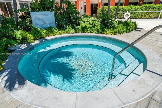 view of pool with a hot tub