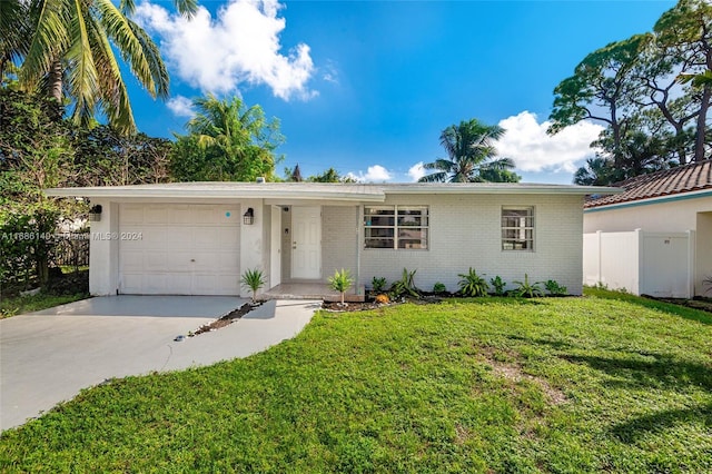 single story home with a garage and a front lawn