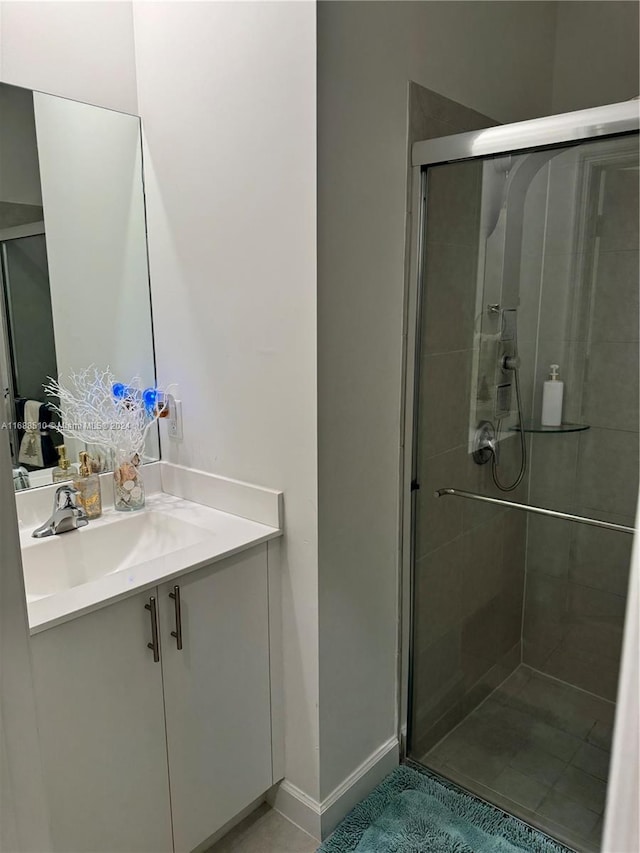 bathroom featuring vanity, tile patterned floors, and a shower with shower door