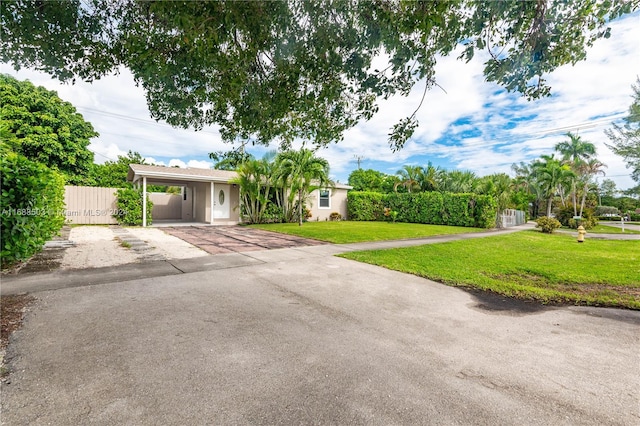 ranch-style house featuring a front lawn and a carport