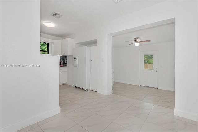 spare room with ceiling fan and plenty of natural light