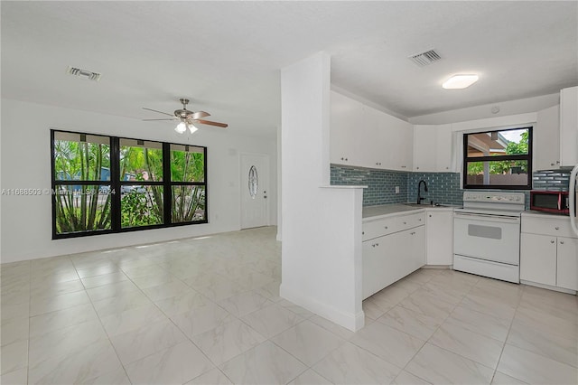 kitchen featuring white cabinetry, backsplash, and white range with electric stovetop