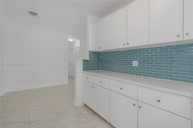 kitchen featuring white cabinets and backsplash