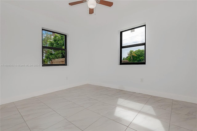 spare room with a wealth of natural light and ceiling fan