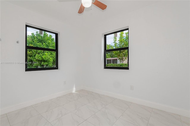 spare room with a wealth of natural light and ceiling fan