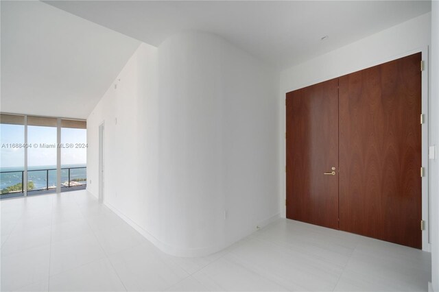 2655 S Bayshore Dr Unit 1602, Coconut Grove, FL 33133 - hallway with floor to ceiling windows and light tile patterned flooring